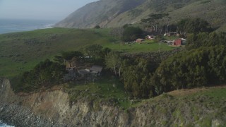 DFKSF03_083 - 5K aerial stock footage fly over coast, approach an oceanfront home, reveal barns, San Simeon, California