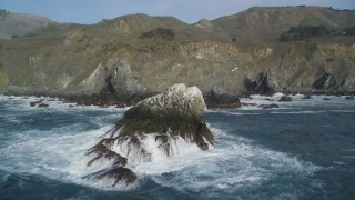 DFKSF03_096 - 5K aerial stock footage fly over a large rock formation and pan across coastal cliffs, Big Sur, California