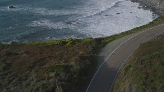 DFKSF03_098 - 5K aerial stock footage of flying over Highway 1 coastal road, and tilt to ocean waves, Big Sur, California