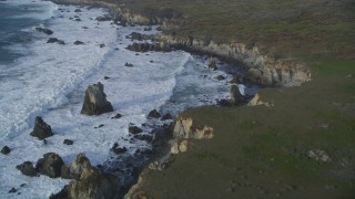 DFKSF03_102 - 5K stock footage aerial video pan from bird's eye view of ocean waves, reveal coastal cliffs, rock formations, Big Sur, California