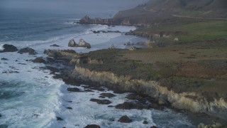 DFKSF03_103 - 5K stock footage aerial video tilt from ocean waves, approach rugged coastal cliffs, rock formations, Big Sur, California