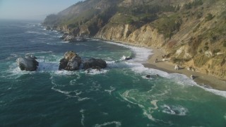 DFKSF03_118 - 5K stock footage aerial video tilt from rock formations in the ocean to reveal coastal cliffs, Big Sur, California