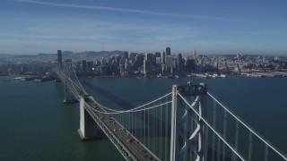 DFKSF05_012 - 5K stock footage aerial video fly over Bay Bridge to approach skyline of Downtown San Francisco, California