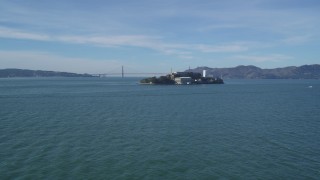 DFKSF05_069 - 5K aerial stock footage approach famous Alcatraz prison, Golden Gate Bridge in the background, San Francisco, California