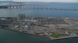 DFKSF06_018 - 5K aerial stock footage of approaching cargo cranes and containers at the Port of Oakland, California