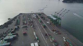 DFKSF06_019 - 5K aerial stock footage of an orbit of the cargo cranes and shipping containers at the Port of Oakland, California