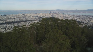 DFKSF06_073 - 5K stock footage aerial video tilt from Mount Sutro forest to reveal skyscrapers in Downtown San Francisco, California