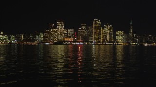 DFKSF07_003 - 5K aerial stock footage of the city skyline at night seen from the bay, Downtown San Francisco, California, night