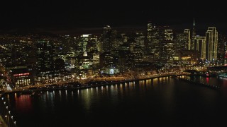 DFKSF07_011 - 5K stock footage aerial video tilt from bay to reveal Bay Bridge and Downtown San Francisco skyscrapers, California, night