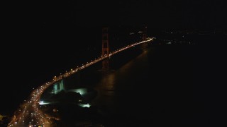 DFKSF07_034 - 5K aerial stock footage tilt from bird's eye of freeway interchange to reveal Golden Gate Bridge, San Francisco, California, night