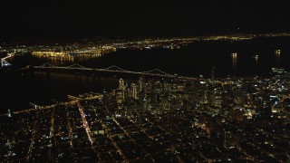 DFKSF07_064 - 5K aerial stock footage of a wide view of the Bay Bridge and Downtown San Francisco skyscrapers, California, night