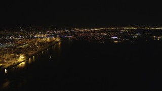 DFKSF07_077 - 5K aerial stock footage of panning across and approaching the Port of Oakland in California, night