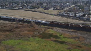 DFKSF08_103 - 5K aerial stock footage of flying by a train traveling past residential neighborhoods, Pittsburg, California