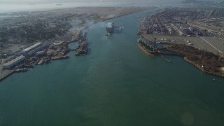 DFKSF09_017 - 5K aerial stock footage of tilting from Oakland Inner Harbor revealing cargo ship in Port of Oakland, California