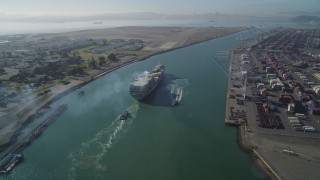 DFKSF09_018 - 5K aerial stock footage of tracking a cargo ship by the Port of Oakland, California