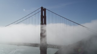 DFKSF09_024 - 5K aerial stock footage of flying by fog pouring over Golden Gate Bridge, San Francisco, California