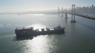 DFKSF09_048 - 5K aerial stock footage track a cargo ship approaching the Bay Bridge, San Francisco, California