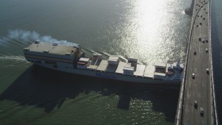 DFKSF09_049 - 5K aerial stock footage of tracking a cargo ship sailing under Bay Bridge, San Francisco, California
