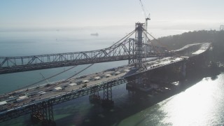 DFKSF09_054 - 5K aerial stock footage of flying by the Bay Bridge and the new span under construction, California