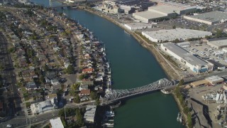 DFKSF09_061 - 5K aerial stock footage of suburban homes in Alameda and warehouse buildings across the estuary in Oakland, California