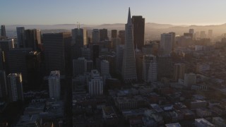DFKSF10_004 - 5K aerial stock footage of flying by downtown skyscrapers and Transamerica Pyramid, Downtown San Francisco, California at sunset
