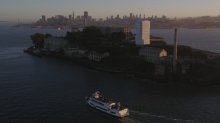 DFKSF10_018 - 5K aerial stock footage of flying by Alcatraz prison in San Francisco, California, sunset
