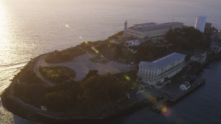 DFKSF10_019 - 5K aerial stock footage of flying over Alcatraz island prison in San Francisco, California, sunset