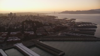 DFKSF10_062 - 5K aerial stock footage pan across San Francisco Bay to reveal Coit Tower, Fisherman's Wharf, California, sunset