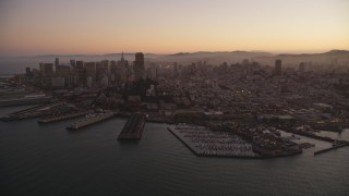 DFKSF10_064 - 5K aerial stock footage of downtown skyscrapers and Coit Tower, reveal Pier 39, Fisherman's Wharf, San Francisco, California, twilight
