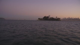 DFKSF10_069 - 5K aerial stock footage of approaching Alcatraz at a low altitude, San Francisco, California, twilight