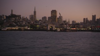 DFKSF10_071 - 5K aerial stock footage of flying over Bay, zoom in on Fisherman's Wharf, San Francisco, California, twilight