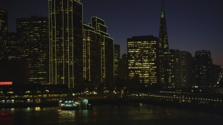 DFKSF10_101 - 5K aerial stock footage of flying by Ferry Building and skyscrapers in Downtown San Francisco, California, night