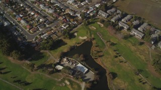 DFKSF11_001 - 5K aerial stock footage fly away from suburban homes and golf course to reveal Hayward Executive Airport, California