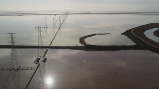 DFKSF11_008 - 5K aerial stock footage of flying by power lines and marshlands, Sunnyvale, California