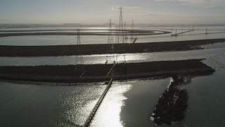 DFKSF11_010 - 5K aerial stock footage of flying over power lines through marshlands, Sunnyvale, California