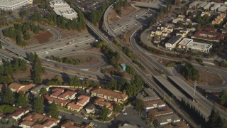DFKSF12_009 - 5K aerial stock footage of a reverse view of the I-280 freeway interchange and tract homes, San Jose, California