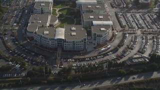 DFKSF12_015 - 5K aerial stock footage tilt from freeway, revealing Apple Headquarters office buildings, Cupertino, California