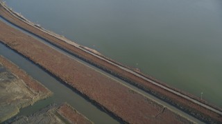 DFKSF12_037 - 5K aerial stock footage of a reverse view of marshlands and canals, Union City, California