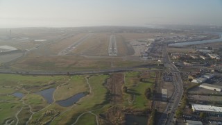 DFKSF12_042 - 5K aerial stock footage tilt from golf course to reveal and approach Oakland International Airport, California