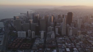 DFKSF14_008 - 5K aerial stock footage approach city skyscrapers, tilt to city streets below in Downtown San Francisco, California, sunset