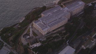 DFKSF14_023 - 5K aerial stock footage of passing the main buildings and lighthouse on Alcatraz, San Francisco, California, twilight