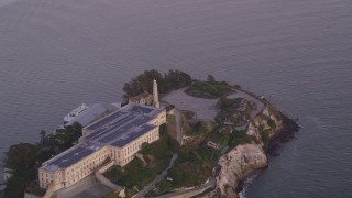 DFKSF14_024 - 5K aerial stock footage of the main buildings and lighthouse on Alcatraz island, San Francisco, California, twilight