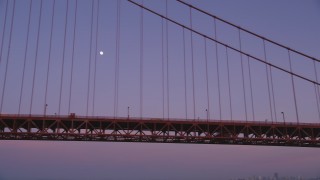 DFKSF14_035 - 5K aerial stock footage of flying by the Golden Gate Bridge with a view of the moon, San Francisco, California, twilight