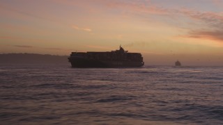 DFKSF14_040 - 5K aerial stock footage of a cargo ship on the San Francisco Bay in San Francisco, California, twilight