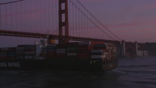 DFKSF14_041 - 5K aerial stock footage orbit cargo ship and reveal Golden Gate Bridge, San Francisco, California, twilight