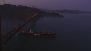 DFKSF14_042 - 5K aerial stock footage fly over Golden Gate Bridge, reveal cargo ship, San Francisco, California, twilight