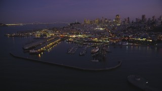 DFKSF14_057 - 5K aerial stock footage of flying by iconic Fisherman's Wharf, San Francisco, California, twilight
