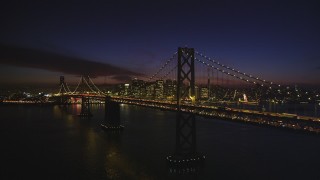 DFKSF14_086 - 5K aerial stock footage of the Bay Bridge, with views of Downtown San Francisco skyscrapers, California, night