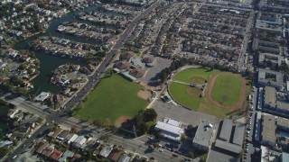 DFKSF15_002 - 5K aerial stock footage of a reverse view of suburban neighborhoods and baseball fields, Alameda, California