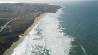 DFKSF15_062 - 5K aerial stock footage of flying over Montara State Beach, tilt revealing coastal neighborhoods, Montara, California